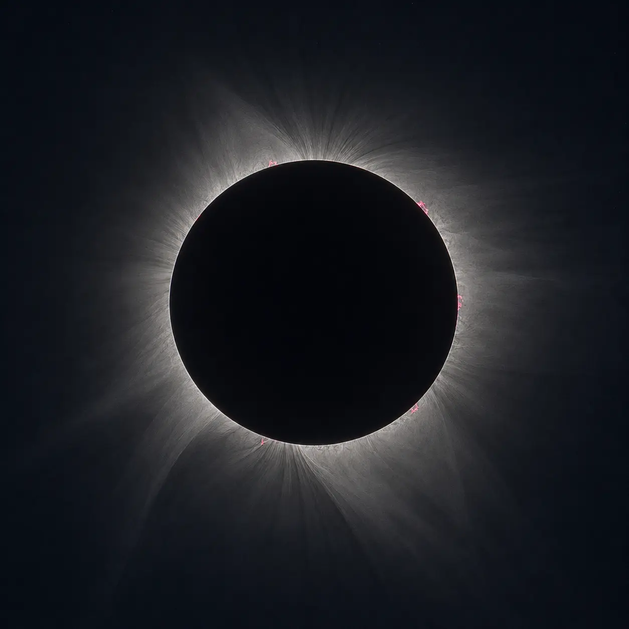 A coroa solar com longos filamentos e penachos a estenderem-se em várias direções.